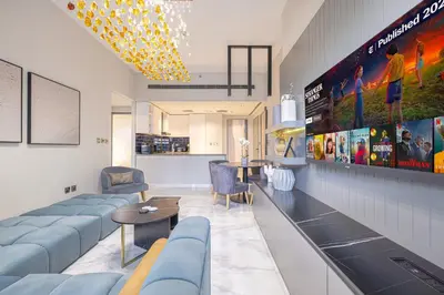 a waiting room with blue couches and a tv at Upscale 2BR in Lively Building in Dubai