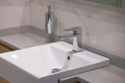 a white sink with a faucet in a bathroom at Upscale 2BR in Lively Building in Dubai