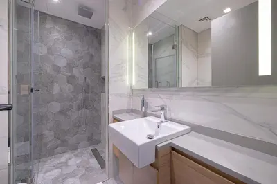a white bathroom with a sink and a shower at Upscale 2BR in Lively Building in Dubai