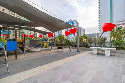 a rooftop with tables and chairs and red lanterns at Upscale 2BR in Lively Building in Dubai