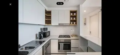 a white kitchen with a stove and a microwave at Downtown holiday home in Dubai
