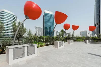 a group of red balloons in a parking lot with buildings at Cozy Studio Steps from Dubai Mall & Burj Khalifa in Dubai