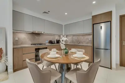 a kitchen with a table and chairs and a refrigerator at Private Beach-Infinity Pool-Lux Beachfront in Dubai