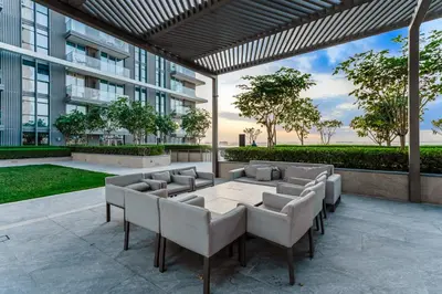 a patio with a table and chairs and a building at Private Beach-Infinity Pool-Lux Beachfront in Dubai
