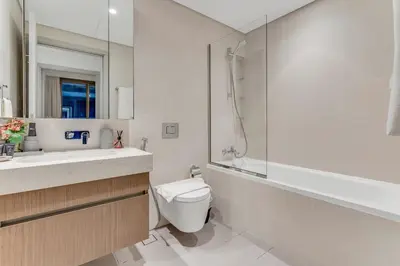 a bathroom with a toilet and a sink and a shower at Private Beach-Infinity Pool-Lux Beachfront in Dubai