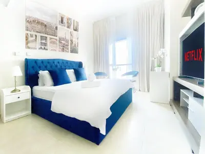 a blue and white bedroom with a bed and a tv at Cozy Studio Dubai Marina by beach & Metro Z1503 in Dubai