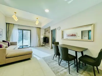 a living room with a couch and a table and chairs at Bab al qarya in Dubai