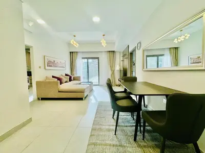 a living room with a table and chairs and a couch at Bab al qarya in Dubai