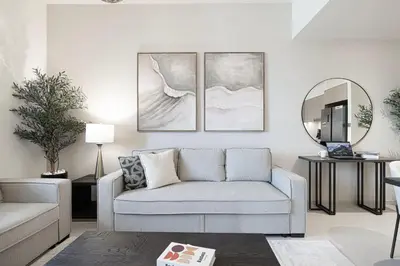 a living room with a couch and a mirror at Sky High Luxury, Grande Signature, Burj Khalifa View, 5 minute walk to Dubai Mall in Dubai