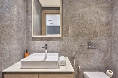 a bathroom with a white sink and a mirror at Luxury 1BR Haven Chic & Cozy Stay in JVC in Dubai