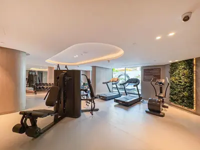 a gym with several exercise equipment in a room at Luxury 1BR Haven Chic & Cozy Stay in JVC in Dubai