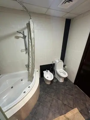 a bathroom with a tub and a toilet and a sink at Marina Haven with Jacuzzi in Dubai
