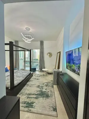 a bedroom with a bed and a flat screen tv at Marina Haven with Jacuzzi in Dubai