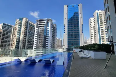 a swimming pool in a city with tall buildings at Studio in downtown with Burj Khalifa and city view in Dubai