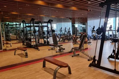 a gym with a lot of treadmills and machines at Studio in downtown with Burj Khalifa and city view in Dubai