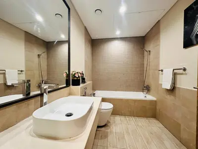 a bathroom with a sink and a tub and a toilet at Airvistas retreat at wasl one residence in Dubai
