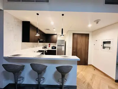 a kitchen with a counter and two stools at Airvistas retreat at wasl one residence in Dubai