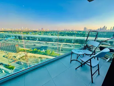 a balcony with two chairs and a view of a city at Airvistas retreat at wasl one residence in Dubai