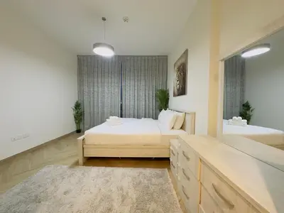 a large bedroom with two beds and a mirror at Airvistas retreat at wasl one residence in Dubai