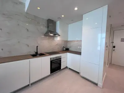 a white kitchen with a sink and a stove at The Burj Panarama in Dubai