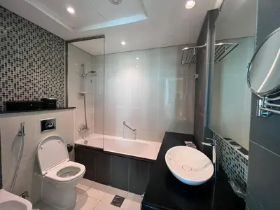 a bathroom with a toilet and a tub and a sink at The Burj Panarama in Dubai