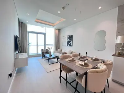 a living room with a table and chairs and a couch at The Burj Panarama in Dubai