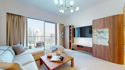 a living room with a couch and a tv at Best 2 bedroom Direct Burj Khalifa Downtown View in Dubai