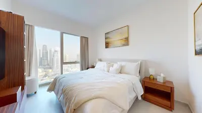 a white bedroom with a bed and a large window at Best 2 bedroom Direct Burj Khalifa Downtown View in Dubai