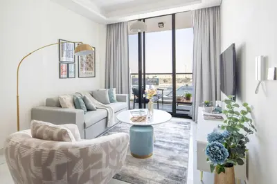 a living room with a couch and a table at Frank Porter - Samana Park Views in Dubai