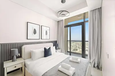 a white bedroom with a large bed and a window at Silkhaus Luxury 2BDR at Aykon City in Business Bay in Dubai