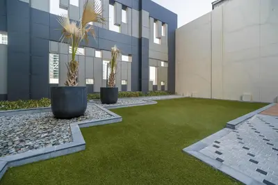 an office building with a green lawn and plants at Cozy and elegant Studio in Business Bay in Dubai