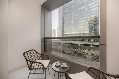 a balcony with chairs and a table and a large window at Cozy and elegant Studio in Business Bay in Dubai