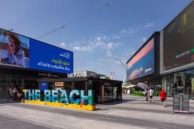 a group of buildings with people walking on a street at Waves - Charming Apt With Balcony Steps From The Beach in Dubai