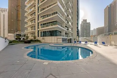 a swimming pool in the middle of a city at Waves - Charming Apt With Balcony Steps From The Beach in Dubai