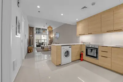 a kitchen with a washer and a washing machine at Waves - Charming Apt With Balcony Steps From The Beach in Dubai