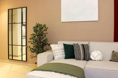 a living room with a white couch and a mirror at Elegant 1BR in Heart of Dubai, Walk to Top Malls in Dubai