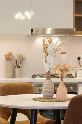 a table with two vases on it in a kitchen at Elegant 1BR in Heart of Dubai, Walk to Top Malls in Dubai