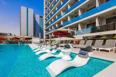 a swimming pool with white lounge chairs and a building at Luxury Studio Near Dubai Mall few mints walk in Dubai