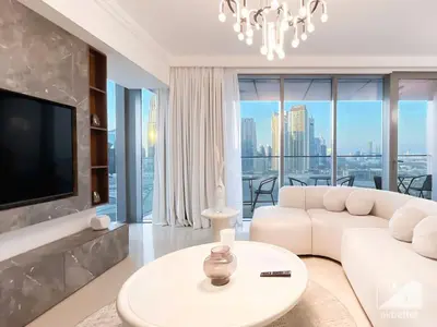 a living room with a white couch and a tv at Elegant 2B at Boulevard Point Burj & Fountain View in Dubai