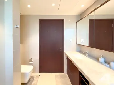 a bathroom with a toilet and a sink and a mirror at Elegant 2B at Boulevard Point Burj & Fountain View in Dubai