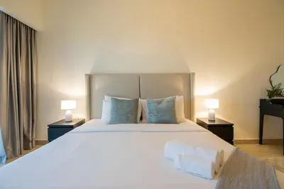a bedroom with a large white bed with two lamps at Central Park Tower DIFC - 10 Minutes Walk to Metro - Spacious 1BDR in Dubai