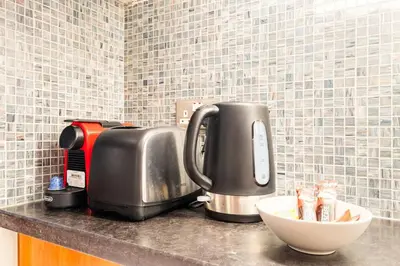 a kitchen counter with a coffee maker and a mixer at Central Park Tower DIFC - 10 Minutes Walk to Metro - Spacious 1BDR in Dubai