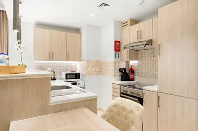 a kitchen with wooden cabinets and a sink at Luxury 1BR in Seven Palm with Beach Access in Dubai
