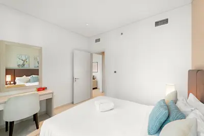 a white bedroom with a desk and a bed at Luxury 1BR in Seven Palm with Beach Access in Dubai