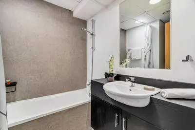 a bathroom with a sink and a mirror and a tub at GuestReady - Elegant studio in JLT in Dubai