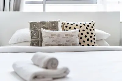 two beds with towels and pillows in a bedroom at GuestReady - Elegant studio in JLT in Dubai