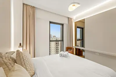 a bedroom with a white bed and a large window at Luxe 1BR in Orchid Creek with Balcony Pool & Gym in Dubai