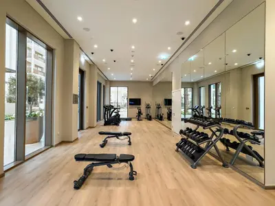 a gym with several treadmills and elliptical machines at Luxe 1BR in Orchid Creek with Balcony Pool & Gym in Dubai