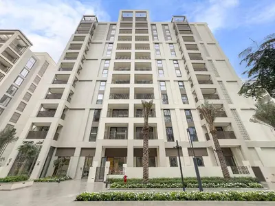 a large white building with palm trees in front of it at Luxe 1BR in Orchid Creek with Balcony Pool & Gym in Dubai