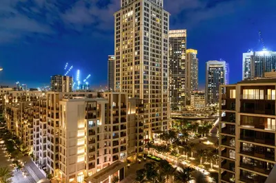 a city skyline at night with tall buildings at Luxe 1BR in Orchid Creek with Balcony Pool & Gym in Dubai